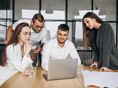 A team of architects and engineers collaborating on a laptop during an IS Code training session in an Ahmedabad.
